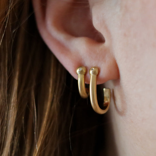 Goldfinch Jewellery. Minimalist 18k diamond set yellow gold hoop earrings with a brushed finish, photographed as a set on model