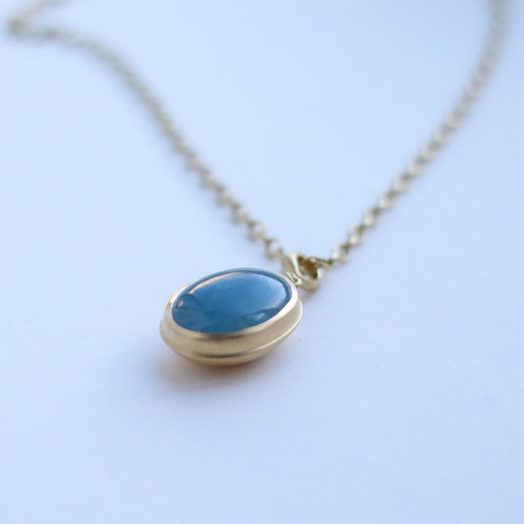 18ct yellow gold aquamarine cabochon brushed gold egg shaped oval domed pendant on belcher chain paper shot angle