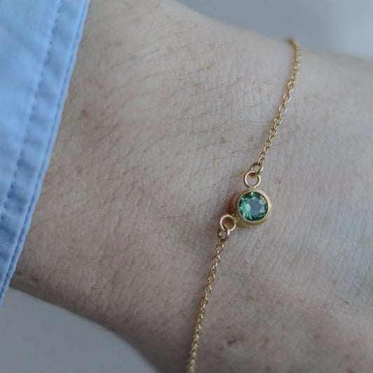 Minimalist brushed 18ct yellow gold necklace featuring a mint green tourmaline on a fine gold chain on model