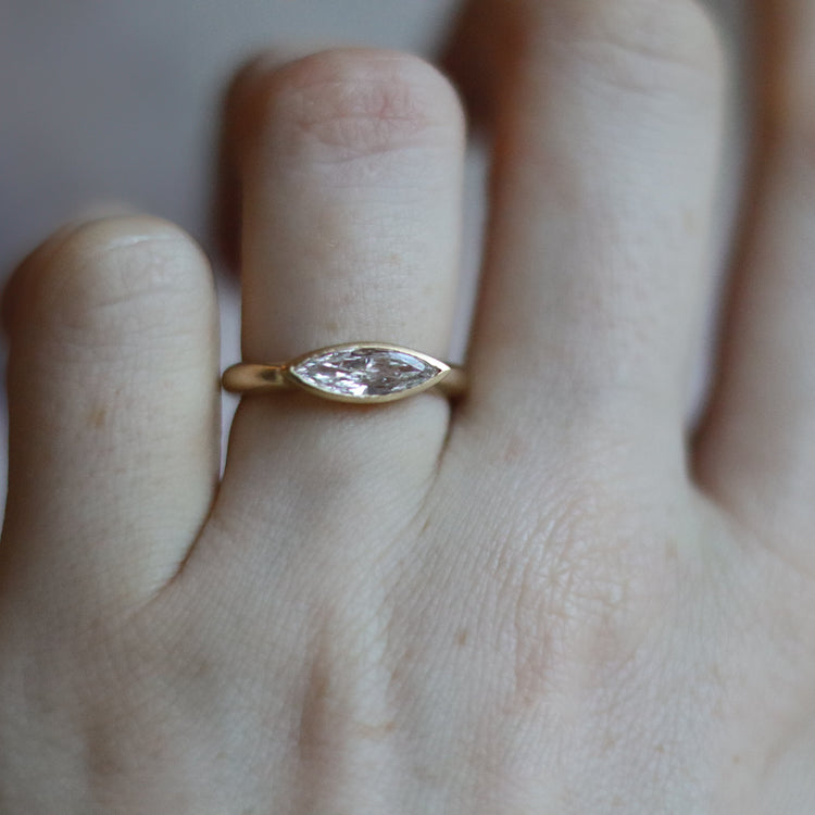 goldfinch jewellery Elegant 18ct yellow gold ring set with a marquise-cut diamond in a minimalist bezel, worn on the finger
