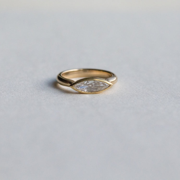 goldfinch jewellery Elegant 18ct yellow gold ring set with a marquise-cut diamond in a minimalist bezel, paper shot