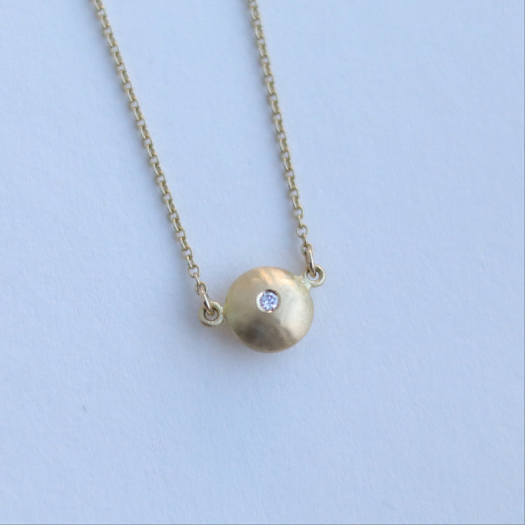 Minimalist 18ct yellow gold pendant necklace featuring a smooth rounded charm in-line on a fine gold chain singular diamond set paper shot