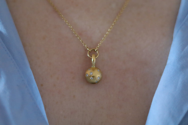 Minimalist solid 18ct yellow gold necklace featuring a brushed gold spherical pendant set with scattered diamonds looped onto a fine solid gold chain on model