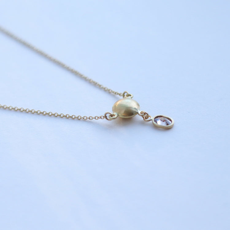 Luxury gold sphere pendant necklace set with diamonds, suspended from a delicate gold chain. shot of back