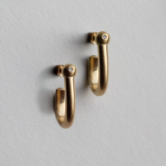 18k yellow gold hoop earrings with a brushed finish, Diamond set sphere, photographed as a matching pair on paper.