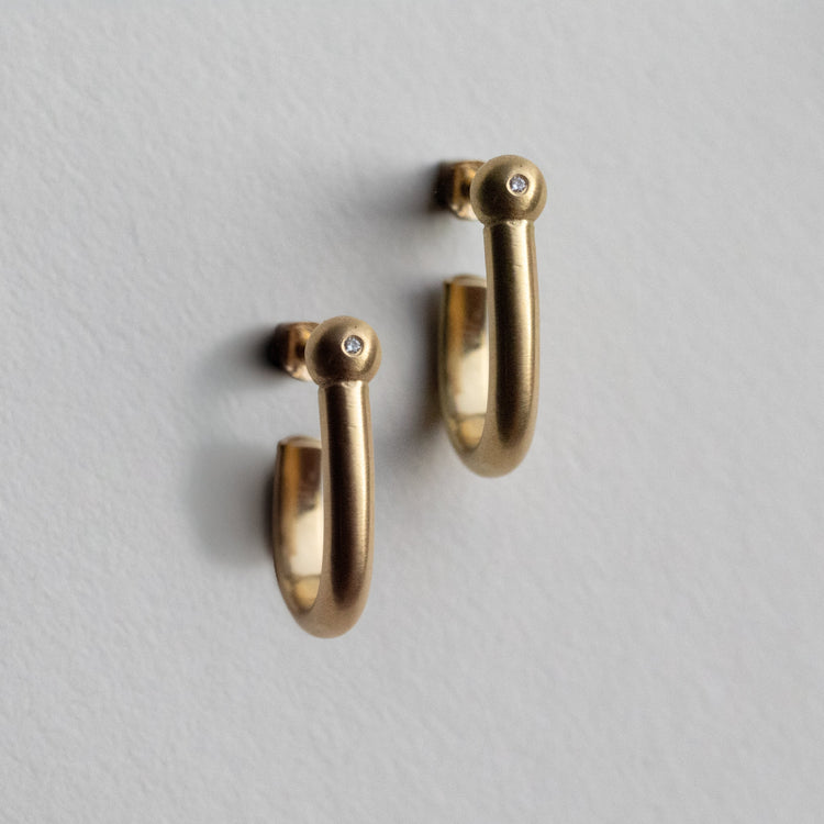 18k yellow gold hoop earrings with a brushed finish, Diamond set sphere, photographed as a matching pair on paper.