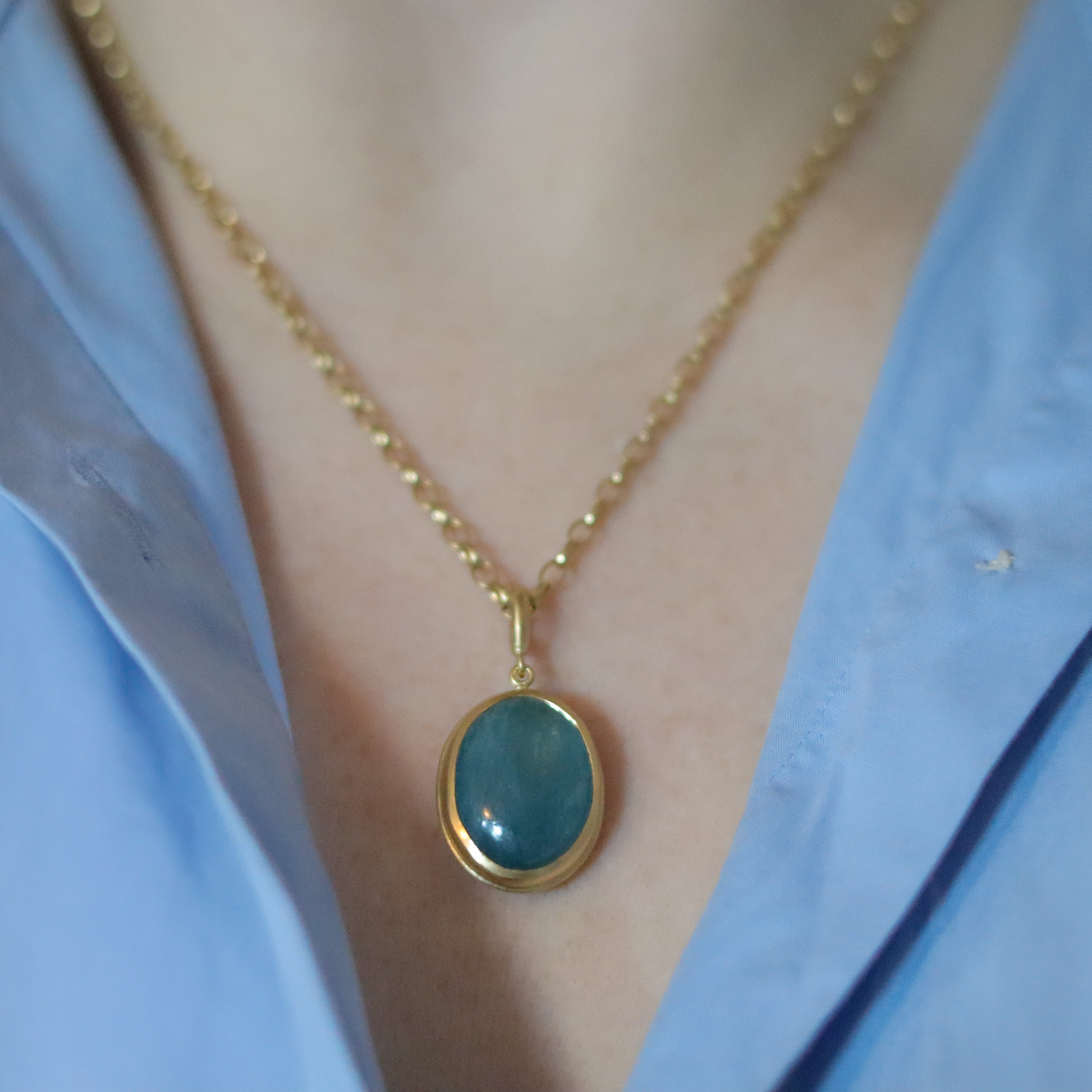 Goldfinch jewellery 18ct yellow gold aquamarine cabochon brushed gold egg shaped oval domed pendant on belcher chain on model