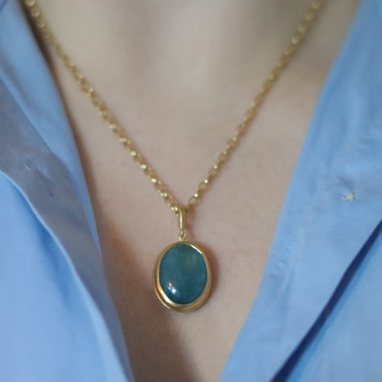 Goldfinch jewellery 18ct yellow gold aquamarine cabochon brushed gold egg shaped oval domed pendant on belcher chain on model