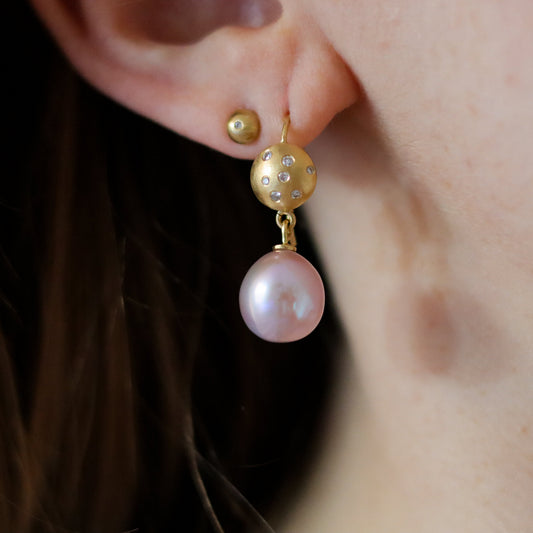 goldfinch jewellery luxury 18ct yellow gold drop earring with diamond-set sphere and blush pink pearl, worn on the ear.