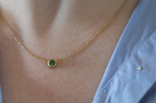 Minimalist brushed 18ct yellow gold necklace featuring a mint green tourmaline on a fine gold chain on model