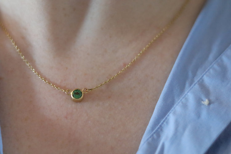 Minimalist brushed 18ct yellow gold necklace featuring a mint green tourmaline on a fine gold chain on model
