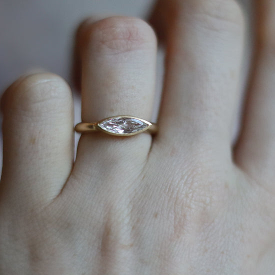 goldfinch jewellery Elegant 18ct yellow gold ring set with a marquise-cut diamond in a minimalist bezel, worn on the finger