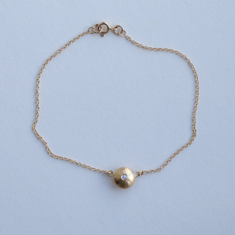 Minimalist 18ct yellow gold pendant necklace featuring a smooth rounded charm in-line on a fine gold chain singular diamond set  paper shot front