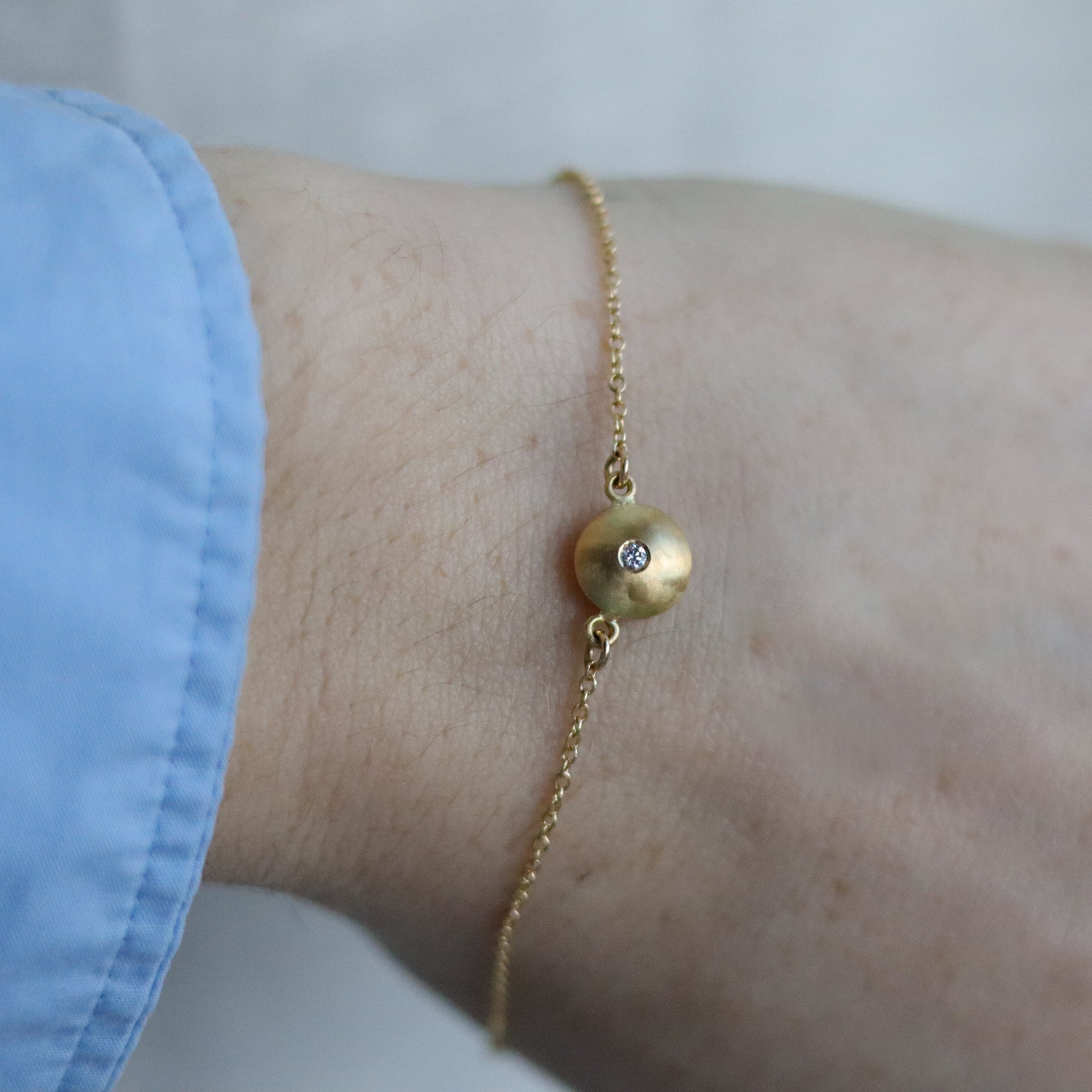 goldfinch jewellery Minimalist 18ct yellow gold pendant necklace featuring a smooth rounded charm in-line on a fine gold chain singular diamond set  model shot