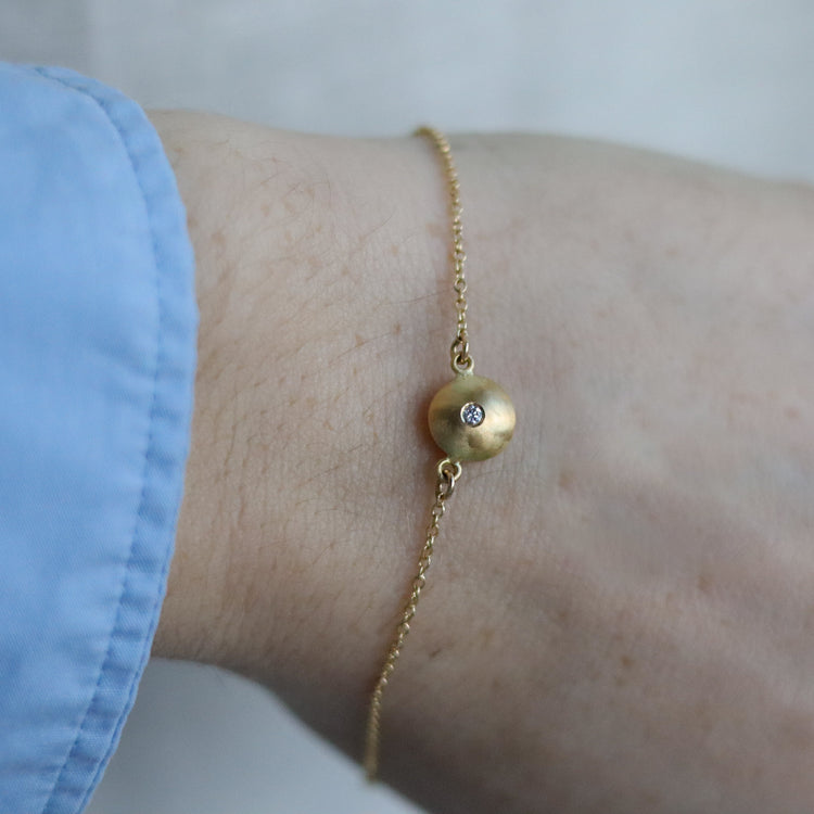 goldfinch jewellery Minimalist 18ct yellow gold pendant necklace featuring a smooth rounded charm in-line on a fine gold chain singular diamond set  model shot