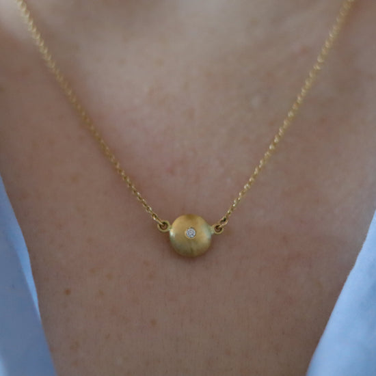 Minimalist 18ct yellow gold pendant necklace featuring a smooth rounded charm in-line on a fine gold chain singular diamond set  - model