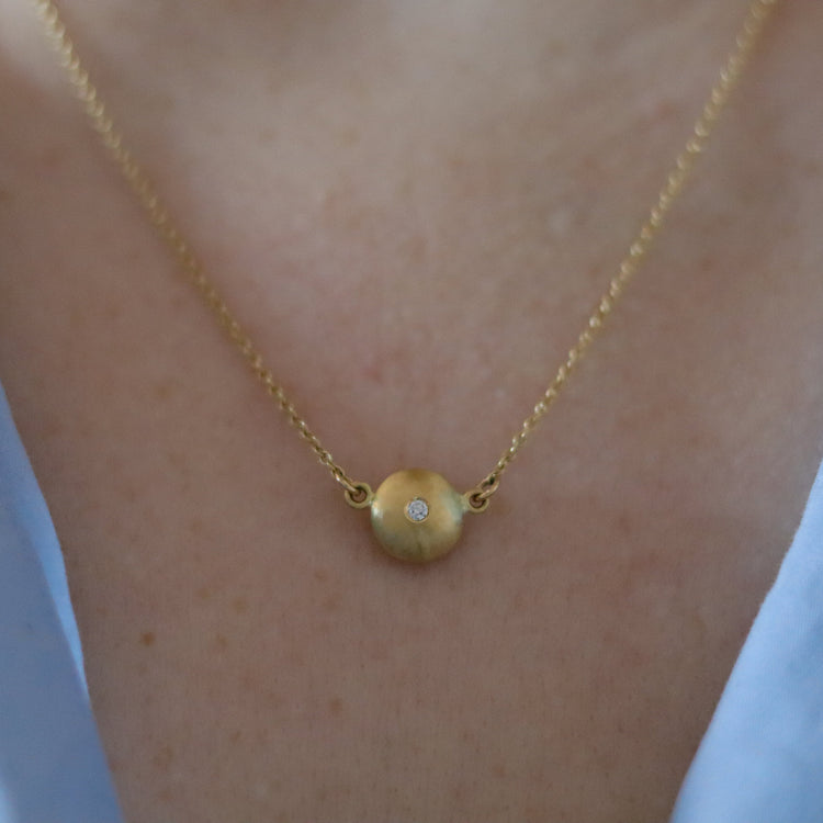 Minimalist 18ct yellow gold pendant necklace featuring a smooth rounded charm in-line on a fine gold chain singular diamond set  - model