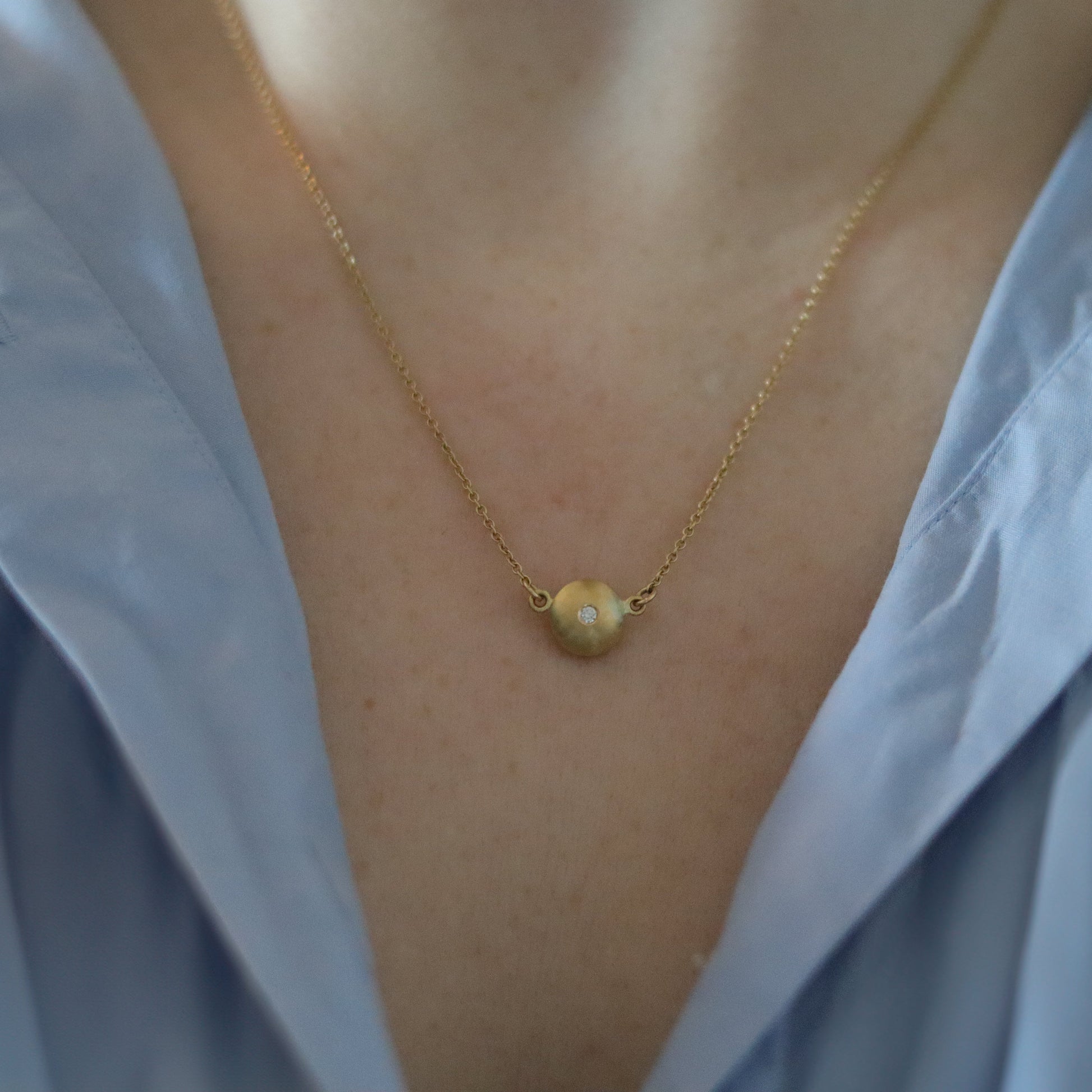 goldfinch jewellery Minimalist 18ct yellow gold pendant necklace featuring a smooth rounded charm in-line on a fine gold chain singular diamond set  shot on model