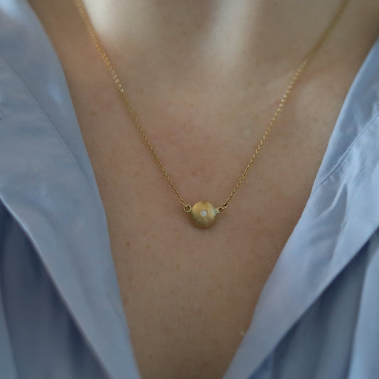 goldfinch jewellery Minimalist 18ct yellow gold pendant necklace featuring a smooth rounded charm in-line on a fine gold chain singular diamond set  shot on model