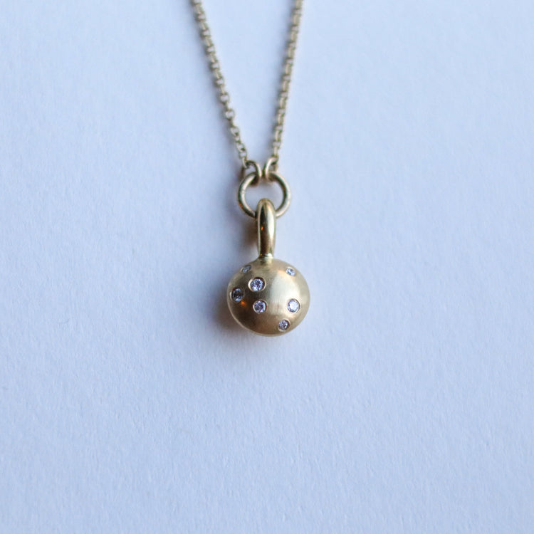 Minimalist solid 18ct yellow gold necklace featuring a brushed gold spherical pendant set with scattered diamonds looped onto a fine solid gold chain