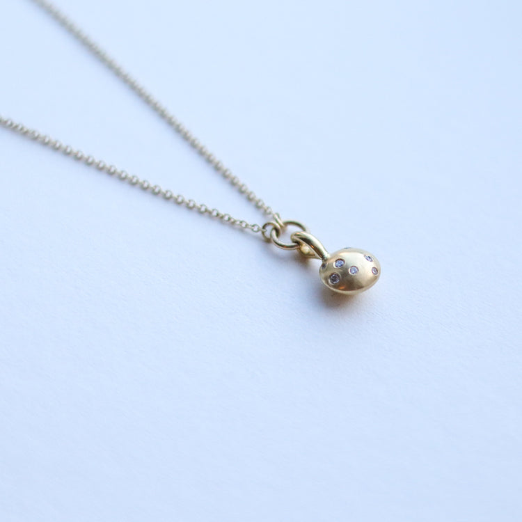 Minimalist solid 18ct yellow gold necklace featuring a brushed gold spherical pendant set with scattered diamonds looped onto a fine solid gold chain